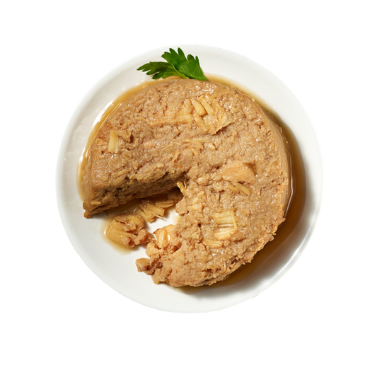 Stella & Chewy's duck & chicken pate dog food with visible chicken chunks and parsley garnish.