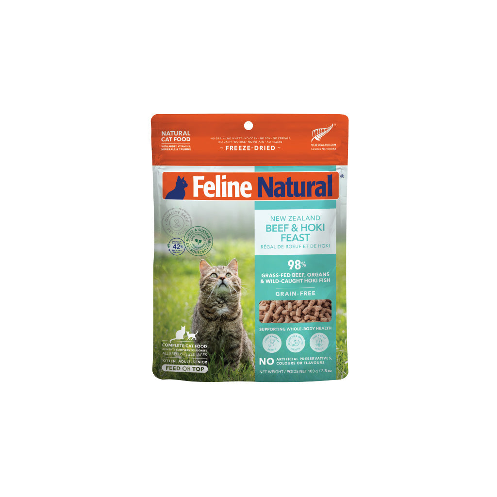 Feline Natural Freeze Dried Beef & Hoki cat food pouch with a tabby cat in a field.