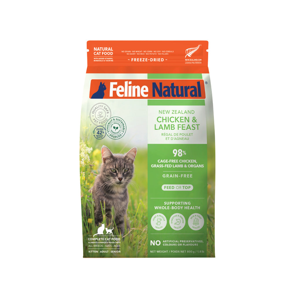 Feline Natural Freeze-Dried Chicken & Lamb cat food bag with a grey tabby cat in a field.
