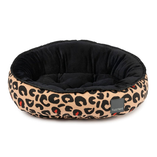 FuzzYard Javan reversible dog bed with black velvety interior and beige leopard print exterior.