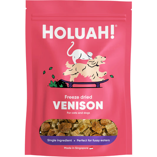 Holuah! 50g freeze-dried venison treats for cats and dogs in a vibrant pink pouch with a clear window showing brown meat cubes.