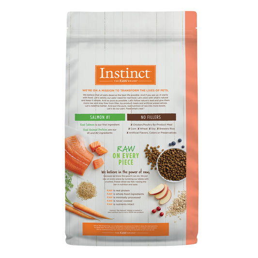 Instinct Be Natural Salmon & Brown Rice dry dog food bag with ingredients like salmon, carrots, and kibble.