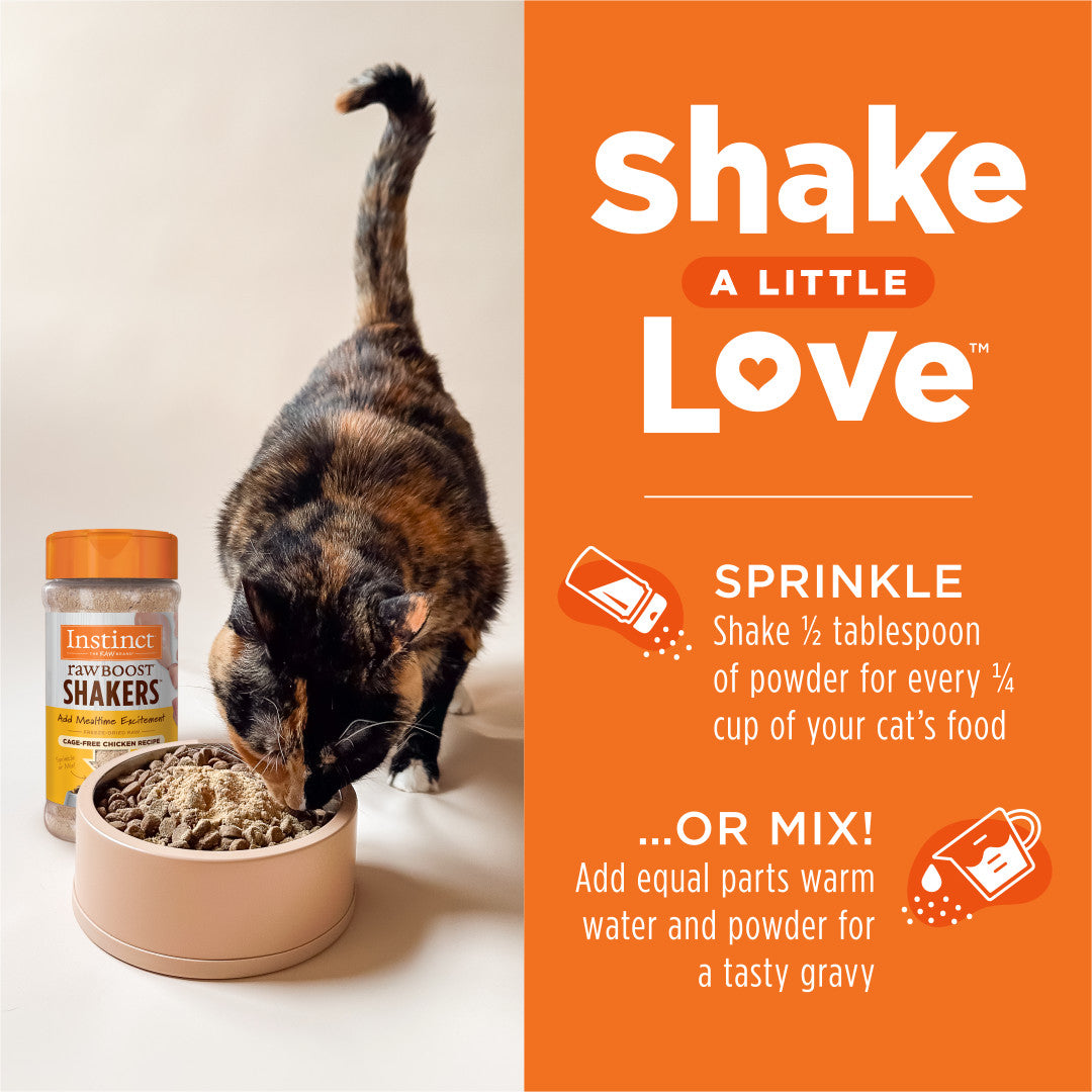 Calico cat eating Instinct Raw Boost Shakers chicken cat food topper from a beige bowl, next to the product jar.