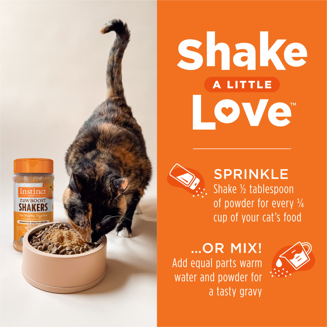 Calico cat eating Instinct Raw Boost Shakers cat food topper from a beige bowl, next to the product bottle.