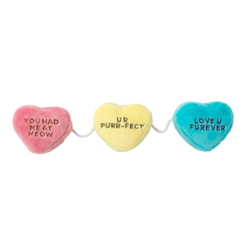 Three plush catnip candy hearts: pink "YOU HAD ME AT MEOW", yellow "UR PURR-FECT", and blue "LOVE U FUREVER".