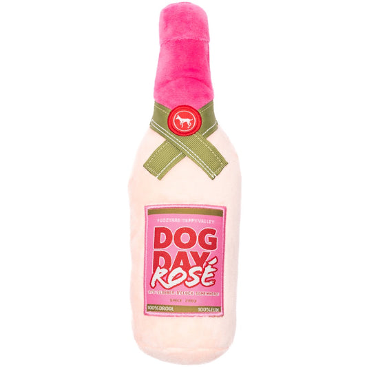 FuzzYard Dog Day Rosé plush dog toy, light pink bottle with a dark pink label and green ribbon.