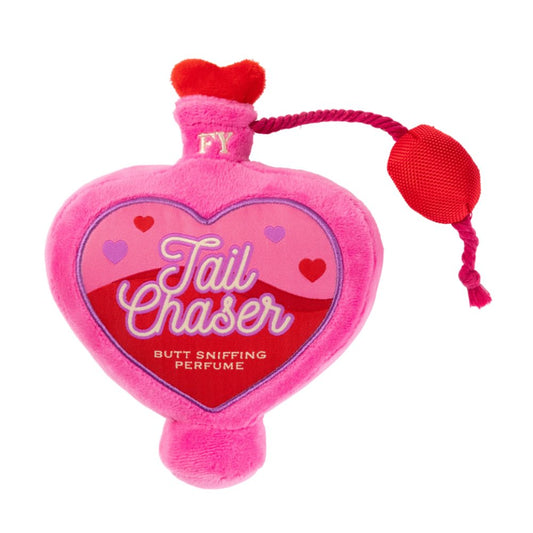 Pink heart-shaped plush dog toy, "Tail Chaser Butt Sniffing Perfume" label, red rope and puff.